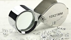 Polished diamonds and loupe. (Shutterstock)